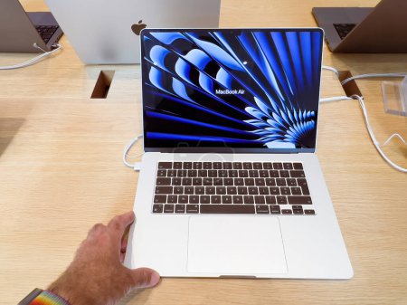 Téléchargez les photos : Strasbourg, France - 10 juillet 2023 : Nouveau MacBook Air nouvel ordinateur portable en argent 15 pouces - l'homme qui travaille pour découvrir ses fonctionnalités - en image libre de droit