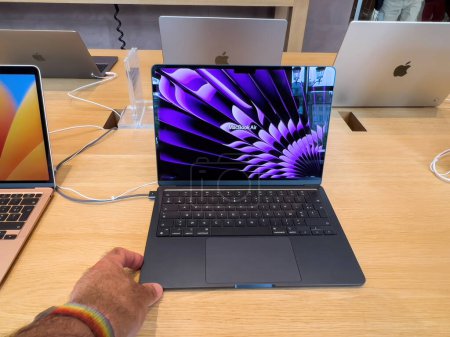 Téléchargez les photos : Strasbourg, France - 10 juillet 2023 : Nouveau MacBook Air nouvel ordinateur portable gris espace de 15 pouces - l'homme qui travaille pour découvrir ses fonctionnalités - en image libre de droit