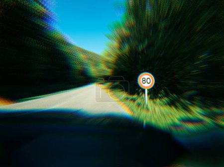 Foto de Efecto de enfoque sobre 80kmph señal de límite de velocidad visto en una carretera pública en el bosque. - Imagen libre de derechos