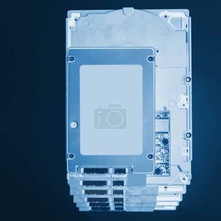Foto de Visión de rayos X sobre la pila de múltiples unidades de disco duro HDD con una moderna unidad de estado sólido SSD rápida colocada por encima de ellos, preparándose para actualizar - Imagen libre de derechos