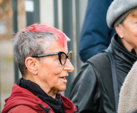 Foto de Estrasburgo, Francia - 29 de marzo de 2023: Retrato lateral de una mujer suiza mayor con el cabello de color rojo protesta pacíficamente frente a la Corte Europea de Derechos Humanos - Imagen libre de derechos
