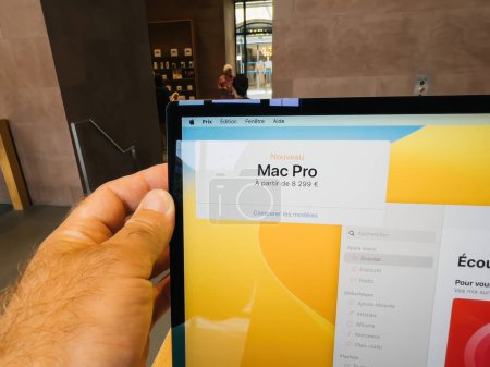 Téléchargez les photos : Strasbourg, France - 10 juil. 2023 : Homme tenant à la main le dernier écran Cinema XDR connecté au Mac Pro avec processeur en silicium M2 au prix de 8,299 euros à l'intérieur de l'Apple Store - en image libre de droit