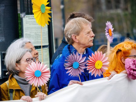 Photo for Strasbourg, France - Mar 29, 2023: Elderly environmental advocates with placards and paper flowers protest for sustainability, a potent message of change - Royalty Free Image