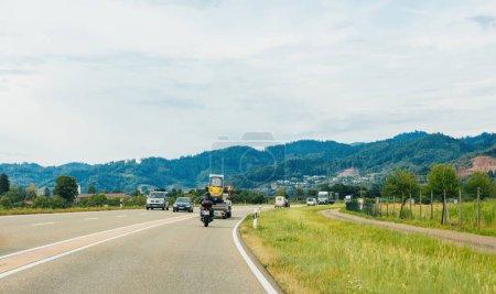 Téléchargez les photos : Schiltach, Allemagne - 14 juil. 2022 : Une personne fait de la moto dans une campagne pittoresque, entourée de verdure et de ciel dégagé. - en image libre de droit