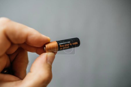 Photo for Paris, France - Jul 12, 2023: Against a gray background, a male hand firmly holds a Duracell AAA battery, with the text "Not for Sale" clearly visible on the packaging. - Royalty Free Image