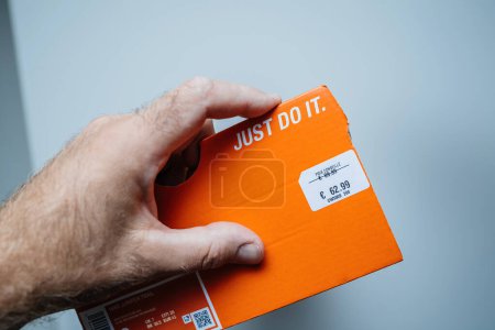 Photo for Paris, France - Jul 12, 2023: POV male hand shows the package proudly displaying a pair of Nike shoes, revealing a discounted price tag thats been slashed from 82.99 to just 62.99. - Royalty Free Image