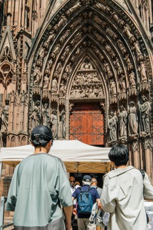 Foto de Estrasburgo, Francia - 7 de julio de 2023: Estrasburgo La catedral de Notre-Dame llama la atención en este punto de vista distintivo, ya que los turistas se maravillan con su grandeza desde la parte trasera - Imagen libre de derechos