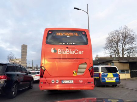 Photo for Kehl, Germany - FEb 18, 2023: An image of the red BlaBlaCar coach bus heading to Munich, captured from the rear, showcases the journeys starting point - police van for control - Royalty Free Image