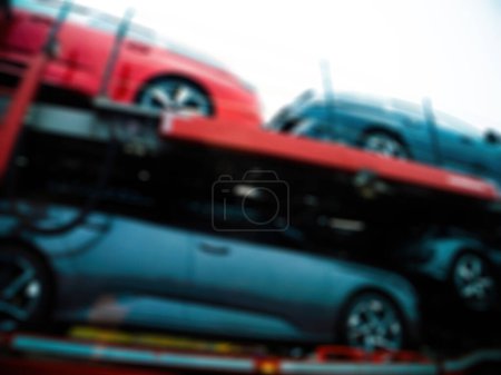 Photo for From a low vantage point, cars on a trailer appear in a defocused manner, creating an abstract and intriguing visual. - Royalty Free Image