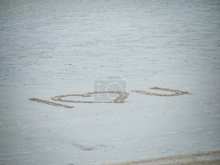 Téléchargez les photos : Sur la plage sereine de Neufchatel-Hardelot, un message sincère déclarant que je t'aime est gravé dans le sable, un geste touchant laissé par une âme amoureuse pour les passants. - en image libre de droit