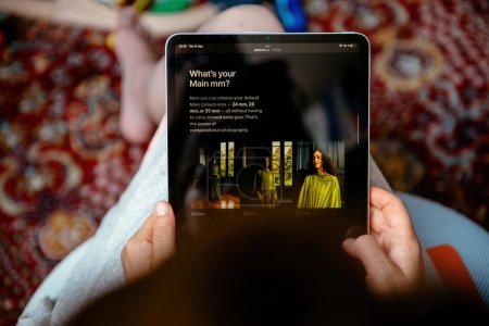 Foto de Londres, Reino Unido - 13 de septiembre de 2023: Mujer analiza Apple.com, leyendo anuncios sobre las nuevas versiones de iPhone 15 Pro y Max con ajustes de cámara versátiles: 24 mm, 28 mm y 35 mm - Imagen libre de derechos