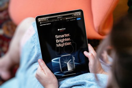Foto de Londres, Reino Unido - 13 de septiembre de 2023: La mujer lee los eslóganes Watch Series 9: Más inteligente, más brillante, más potente en Apple.com durante la presentación de Apple Computers - Imagen libre de derechos