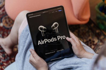 Téléchargez les photos : Londres, Royaume-Uni - 13 sept. 2023 : Femme prend connaissance des dernières innovations sur la nouvelle page AirPods Pro de son iPad Apple, avec le site Web Apple.com - en image libre de droit