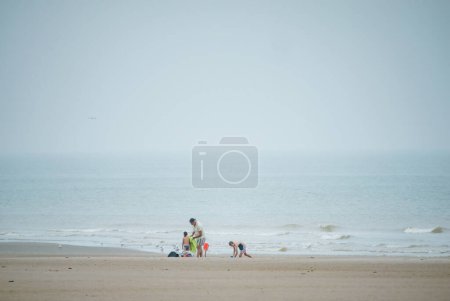 Téléchargez les photos : Neufchatel-Hardelot, France - 18 août 2023 : Un père célibataire et ses deux enfants profitent d'une journée de plaisir à Hardelot Plage Beach, même sous la pluie - en image libre de droit