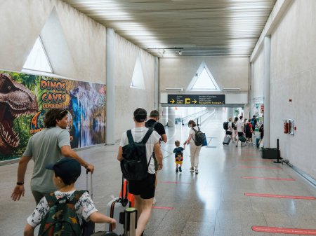 Téléchargez les photos : Palma, Espagne - 22 juin 2023 : À l'intérieur de l'aéroport animé de Palma de Majorque, les passagers avec bagages se déplacent entre les terminaux dans une atmosphère sécurisée et familiale. - en image libre de droit