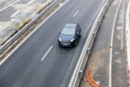 Foto de Una vista aérea y desenfocada captura un coche en movimiento en la bulliciosa carretera urbana. - Imagen libre de derechos