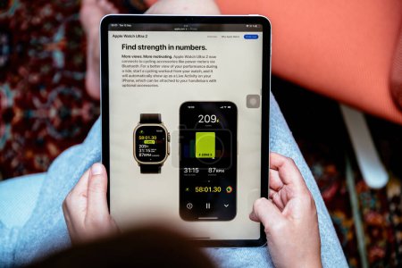 Photo for London, UK - Sep 13, 2023: a woman explores the official website, reading about the Apple Watch Ultra 2s ability to connect with cycling accessories via Bluetooth - Royalty Free Image