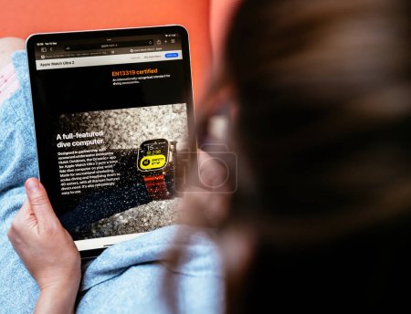 Téléchargez les photos : Londres, Royaume-Uni - 13 sept. 2023 : une femme explore le site apple.com, approfondissant la description de la nouvelle Watch Ultra Series 2, surlignée comme un ordinateur de plongée complet. - en image libre de droit