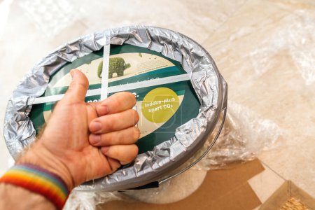 Photo for Frankfurt, Germany - Sep 13, 2023: hand showing a big thumb-up above a large Indeko Plus plastic pot filled with Caparols CapaGreen ecological interior paint, indicating successful delivery with - Royalty Free Image