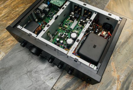 Foto de Un detallado primer plano de una tapa metálica abierta expone los componentes de un nuevo amplificador de música Hi-Fi Clase D. - Imagen libre de derechos