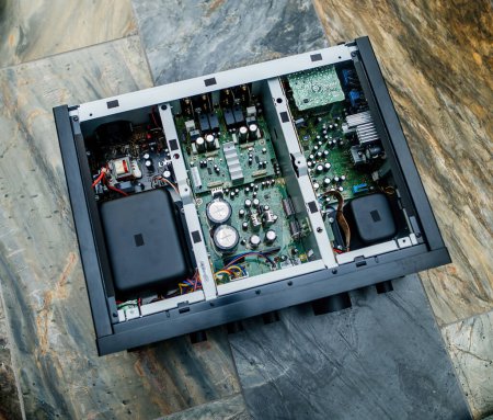 Téléchargez les photos : Un couvercle métallique ouvert sur un nouvel amplificateur Hi-Fi de classe D dévoile une gamme complexe de composants internes. - en image libre de droit