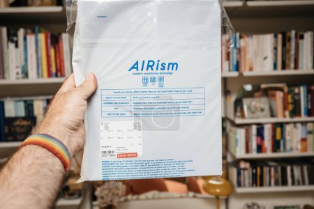 Photo for Paris, France - Jul 5, 2023: Male hand reads instructions and notes special price of 19.90 on an Airism fitted sheet package, showing interest in both the deal and product features - Royalty Free Image