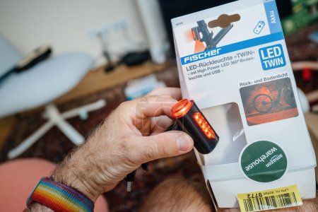Photo for Paris, France - Jul 5, 2023: Male hand holds a German Fischer LED Ruckleuchte with USB charging, delivered by Amazon Warehouse, highlighting product and delivery service - Royalty Free Image