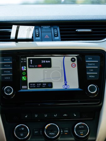 Foto de Francia - 17 / 08 / 2023: Apple Computers iOS CarPlay se muestra en el tablero de instrumentos de un automóvil de lujo, con mapas de navegación, un rango restante de 153 km, hora de llegada proyectada y giro a giro - Imagen libre de derechos