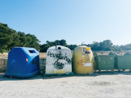 Foto de Mallorca, España - 30 de junio de 2023: En una zona de aparcamiento público en Mallorca, los contenedores de basura muestran el mensaje Feutschen Aus que se traduce al inglés como German People Go Away. - Imagen libre de derechos