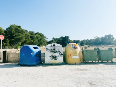 Foto de Mallorca, España - 30 de junio de 2023: Una imagen ultra amplia captura el controvertido mensaje "Feutschen Aus" sobre los contenedores de basura en una zona de aparcamiento público en Mallorca, traducido como "German People Go Away. - Imagen libre de derechos