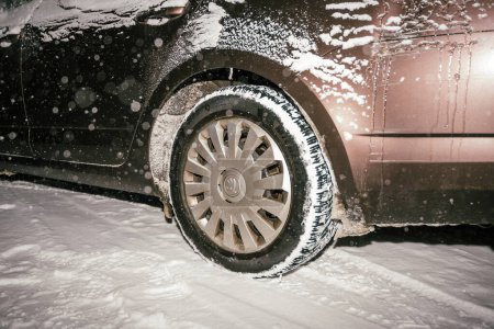 Foto de Francia - 18 de diciembre de 2022: Durante una tormenta de nieve, un coche se cubre con una gruesa capa de hielo y nieve, encapsulando el vehículo en inviernos, concentrándose en los neumáticos de nieve Michelin en una skoda - Imagen libre de derechos