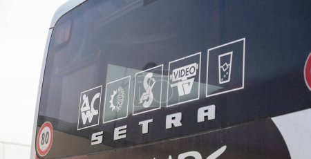 Foto de París, Francia - 20-nov-2022: La vista trasera de un autobús Setra muestra una variedad de pictogramas, que significan comodidades como un baño, aire acondicionado, asientos reclinables, televisión por video y bebidas frías - Imagen libre de derechos