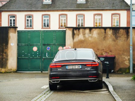Téléchargez les photos : Haguenau, France - 30 nov. 2023 : Une Audi A8 Long 5.0 TDI avec insigne Quattro est stationnée élégamment sur une rue française à Haguenau, incarnant un service de taxi de luxe - en image libre de droit