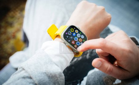 Photo for London, United Kingdom - Sep 20, 2023: a woman presents all the apps on the Apple Computers Watch Ultra 2, which she stylishly wears, marking a significant milestone in technology. - Royalty Free Image