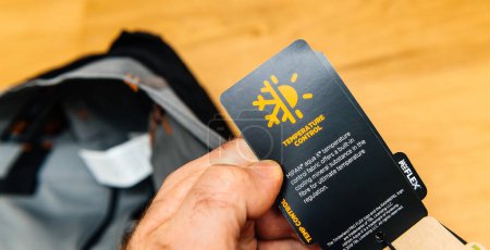 Foto de Hamburgo, Alemania - 16-feb-2022: la mano masculina sostiene con confianza un par de pantalones de trabajo Timberland Flex fabricados con el innovador tejido MIPAN aqua X de control de temperatura - Imagen libre de derechos