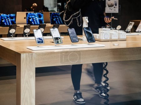 Photo for Paris, France - Sep 22, 2023: A woman is carefully considering her choices for the iPhone 15 Pro inside the Apple Store on the devices official release day. - Royalty Free Image