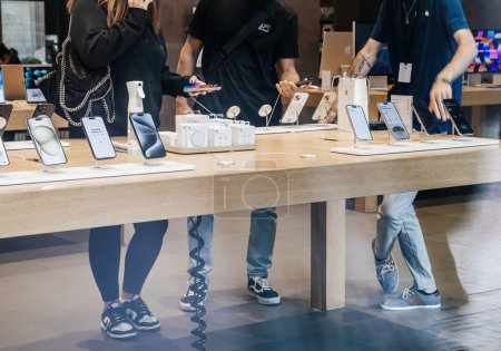 Photo for Paris, France - Sep 22, 2023: An Apple Genius employee adeptly counsels customers on the optimal iPhone 15 Pro Max choices during the devices official launch day - Royalty Free Image