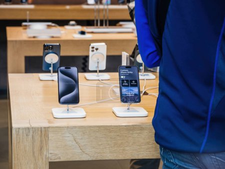 Foto de París, Francia - 22-sep-2023: Dentro del Apple Store, un cliente se encuentra junto a los últimos Apple Computers iPhone 15 Pro, impecablemente diseñados en titanio. - Imagen libre de derechos