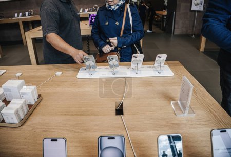 Photo for Paris, France - Sep 22, 2023: Inside the Apple Store on launch day, an adult woman and man intently examine the latest iPhone 15 Pro, deliberating over which model to purchase - Royalty Free Image
