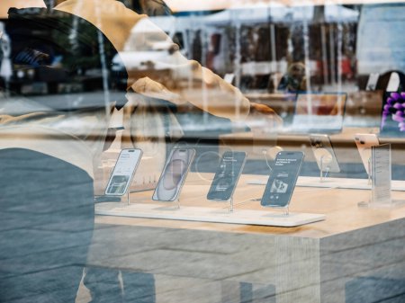 Foto de París, Francia - 22-sep-2023: Desde la calle, los clientes dentro de una tienda de Apple Computer se ven interactuando con los últimos modelos de iPhone 15 Pro y 15 - Imagen libre de derechos