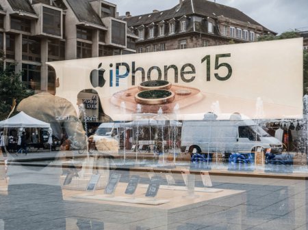 Foto de París, Francia - 22-sep-2023: Una vista a nivel de calle revela a los clientes en la Apple Computer Store absortos en los últimos modelos iPhone 15 y 15 Pro, complementados por una gran pancarta promocional para - Imagen libre de derechos