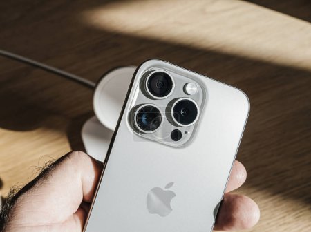 Foto de París, Francia - 22-sep-2023: El iPhone 15 Pro de titanio se sostiene en una mano masculina, centrándose en su configuración de triple cámara que cuenta con capacidades superiores de sensores de fotografía - Imagen libre de derechos