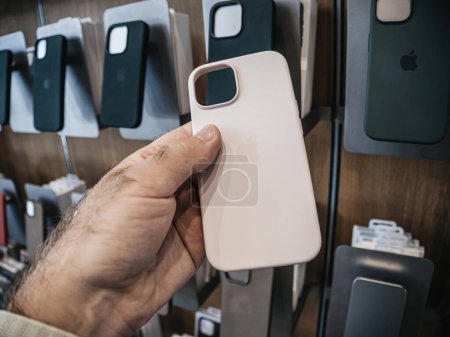 Téléchargez les photos : Paris, France - 22 sept. 2023 : Dans l'Apple Store, une main masculine tient une coque en silicone dotée de la compatibilité MagSafe, destinée à l'iPhone 15 Pro - en image libre de droit