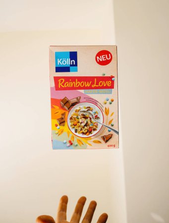 Téléchargez les photos : Francfort, Allemagne - 12 juin 2023 : Une main masculine attrape un paquet de céréales Rainbow Love, fabriqué par Koln en Allemagne. - en image libre de droit