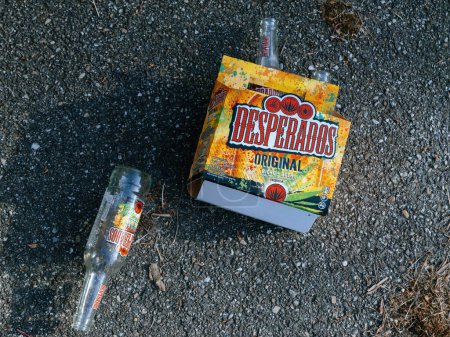 Photo for Paris, France - May 8, 2023: Discarded Desperados Original beer bottle and cardboard left on asphalt, remnants of a party - Royalty Free Image