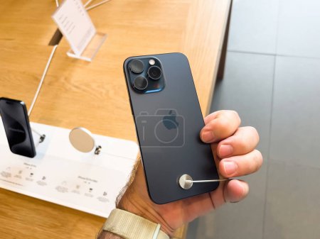 Téléchargez les photos : Paris, France - 22 sept. 2023 : Vue arrière du nouvel iPhone 15 Pro en titane avec triple caméra, présentant ses fonctionnalités avancées, à l'intérieur d'un Apple Store le jour du lancement. - en image libre de droit