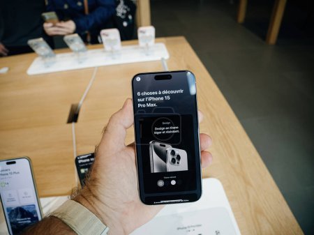 Foto de París, Francia - 22-sep-2023: Universo del iPhone 15 Pro Max texto en pantalla en el último teléfono inteligente de Apple, en poder de un hombre durante el día de lanzamiento en una tienda de Apple - promocionado como el mejor - Imagen libre de derechos
