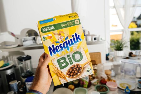 Photo for Frankfurt, Germany - Jun 12, 2023: A male hand holds a package of Nesquik Bio morning cereals, prominently featuring a Nutri-Score A label. - Royalty Free Image