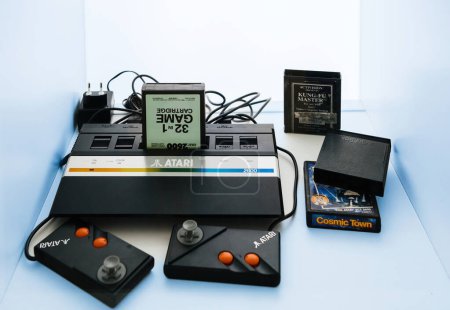 Foto de Alemania - 14 de julio de 2020: La consola de juegos Atari 2600, diseñada como un objeto héroe, se muestra con múltiples accesorios y un cartucho de juego 32 en 1. - Imagen libre de derechos