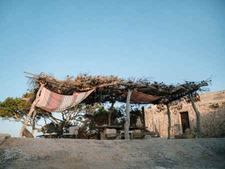 Téléchargez les photos : Une maison de pêcheur solitude sur un rocher, observant les environs dans une zone de loisirs paisible près de Sa Rapita, Majorque, avec maison au loin - en image libre de droit